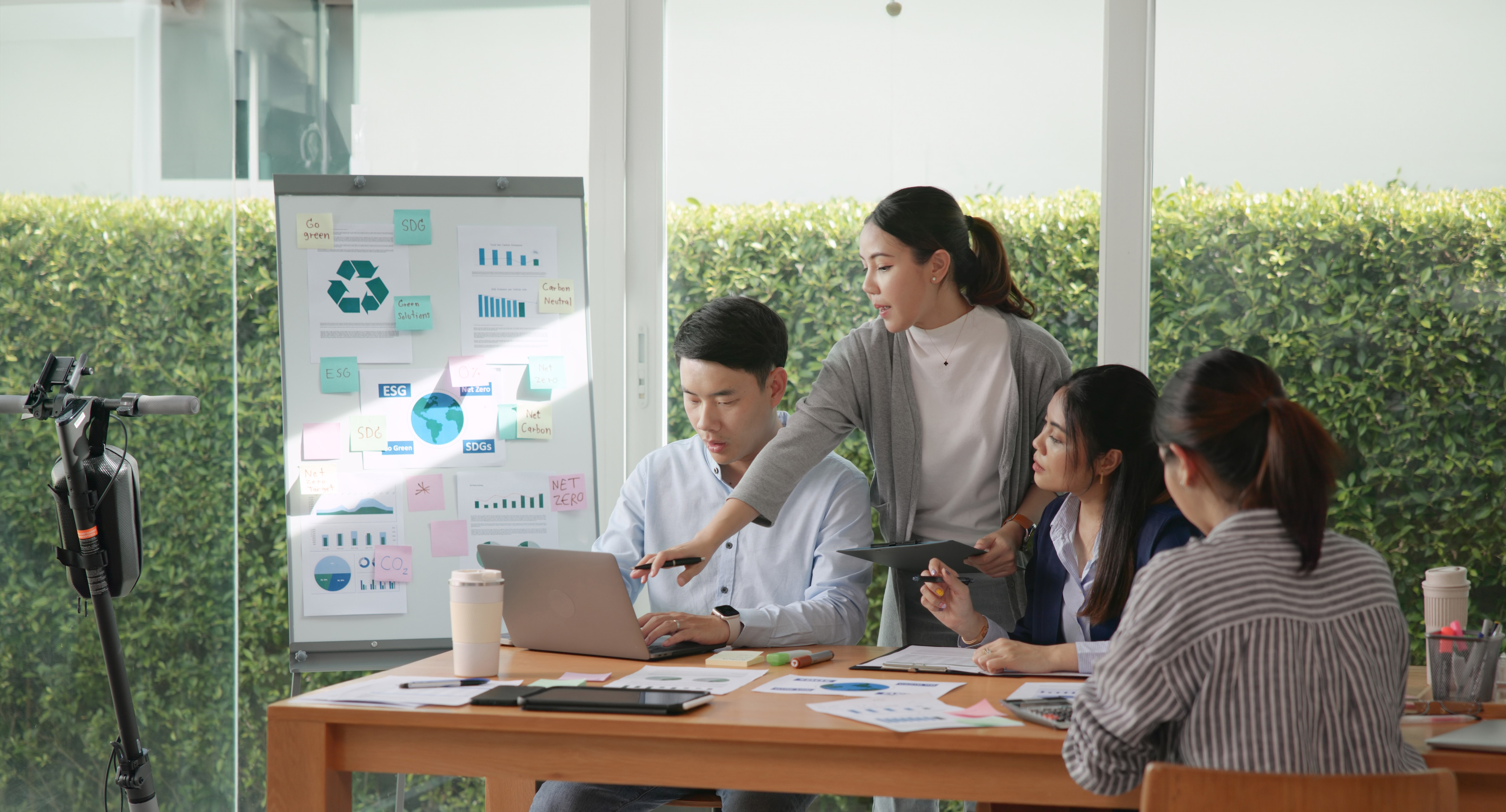 Engineers working together to solve sustainability challenges with data chart in background