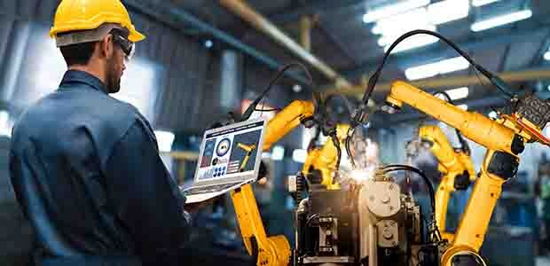 生产工人在工厂车间管理一台工业协作机器人。