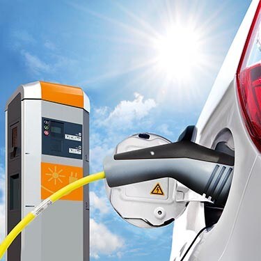 一名男士和女士在电动汽车充电站为他们的电动汽车充电。